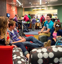Four students sitting in a circle in the MUC lounge pit